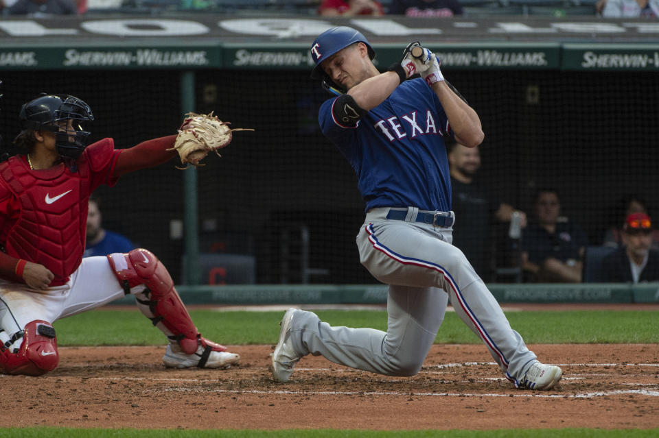 Texas Rangers' Corey Seager, right, ducks away from an inside pitch by Cleveland Guardians starter Tanner Bibee as Guardians' Bo Naylor, left, makes a catch during the third inning of a baseball game in Cleveland, Saturday, Sept. 16, 2023. (AP Photo/Phil Long)