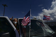 Supporters of President Donald Trump gather moments before leaving for the headquarters of the Republican party in support of his candidacy a few weeks before the presidential election next November, in Carolina, Puerto Rico, Sunday, Oct. 18, 2020. President Donald Trump and former Vice President Joe Biden are targeting Puerto Rico in a way never seen before to gather the attention of tens of thousands of potential voters in the battleground state of Florida. (AP Photo/Carlos Giusti)