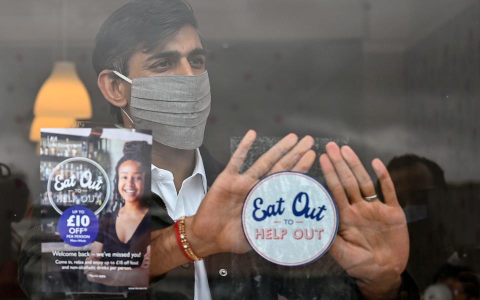 Then-chancellor Rishi Sunak places an Eat Out to Help Out sticker in the window of a business