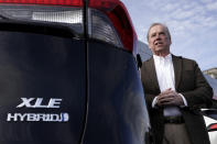 Scott Adams, owner of Adams Toyota, stands with a hybrid Toyota RAV4 at his dealership Tuesday, Dec. 12, 2023, in Lee's Summit, Mo. A typical hybrid costs somewhat more than its gasoline counterpart. A Toyota RAV4 hybrid with all-wheel-drive, for example, starts at $32,825, $1,600 more than a comparable gas version. (AP Photo/Charlie Riedel)