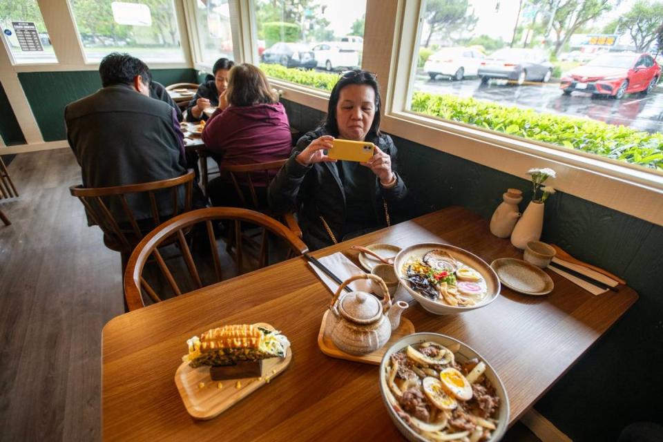 Rhea Pedrosa toma una foto de su almuerzo en el restaurante Engawa Fusion de Stockton Boulevard, en el sur de Sacramento, el sábado 4 de mayo de 2024.