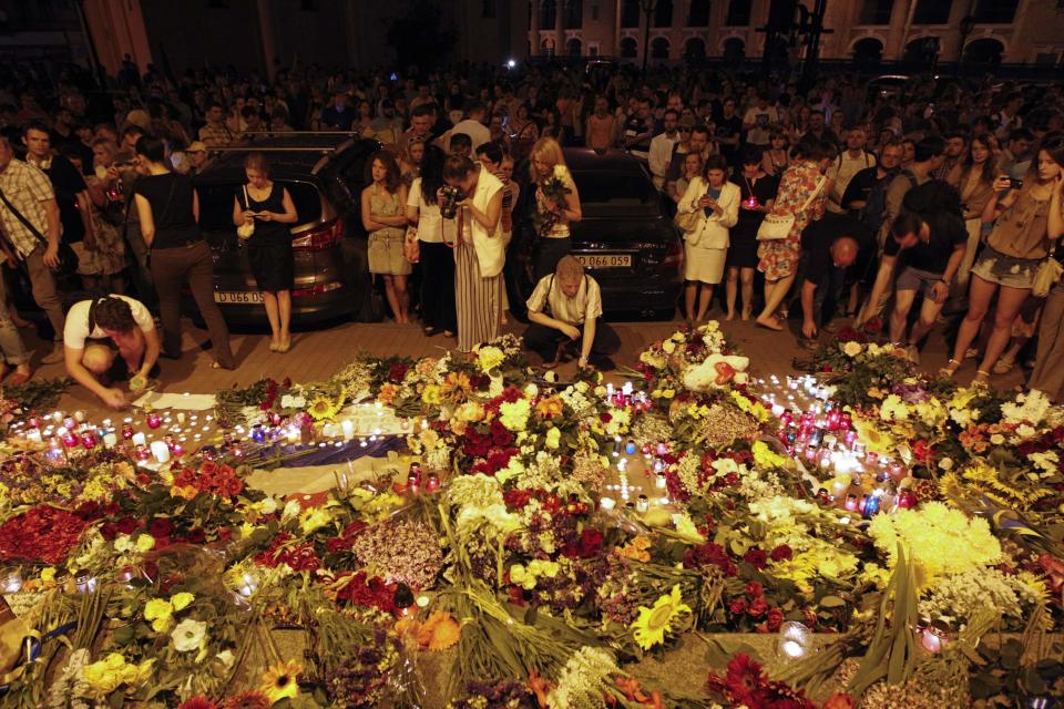 People leave candles and flowers at the Dutch embassy for victims of Malaysia Airlines MH17, which crashed in eastern Ukraine, in Kiev July 17, 2014. The Malaysia Airlines Boeing 777, flying from Amsterdam to Kuala Lumpur, was brought down in eastern Ukraine on Thursday, killing all 295 people aboard and sharply raising the stakes in a conflict between Kiev and pro-Moscow rebels. REUTERS/Valentyn Ogirenko (UKRAINE - Tags: TRANSPORT DISASTER)