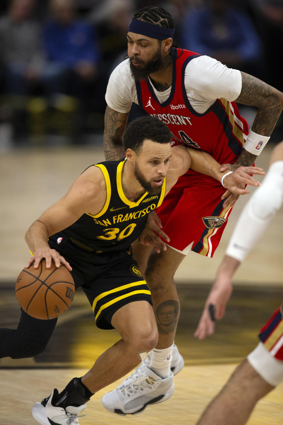 Golden State Warriors guard Stephen Curry (30) drives past New Orleans Pelicans forward Brandon Ingram (14) during the second quarter of an NBA basketball game, Wednesday, Jan. 10, 2024, in San Francisco. (AP Photo/D. Ross Cameron)