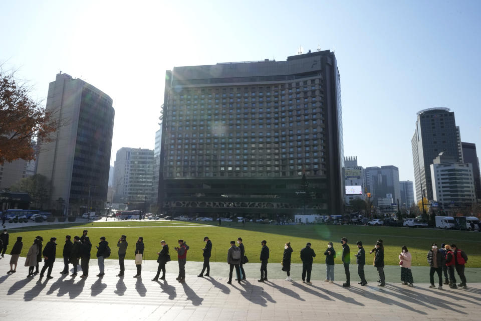 People queue in line to wait for the coronavirus testing at a makeshift testing site in Seoul, South Korea, Wednesday, Nov. 24, 2021. New coronavirus infections in South Korea exceeded 4,000 in a day for the first time since the start of the pandemic as a delta-driven spread continues to rattle the country after it eased social distancing in recent weeks to improve its economy. (AP Photo/Ahn Young-joon).