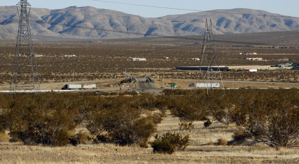 FILE - The site, foreground, on the outskirts of Victorville, Calif., of a proposed station for a high-speed rail line to Las Vegas, is seen with Interstate 15 in the background, on Jan. 25, 2012. A bipartisan congressional group from Nevada and California asked the Biden administration on Monday, April 24, 2023, to fast-track federal funds for Brightline, a private company, to build a high-speed rail line between Las Vegas and the Los Angeles area. (AP Photo/Reed Saxon, File)