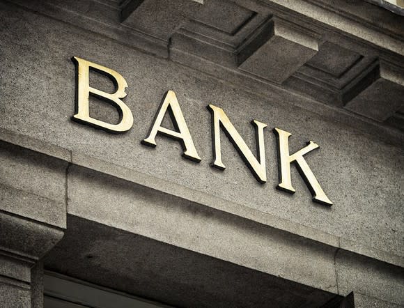 Letters spelling out "bank" on a stone building facade.