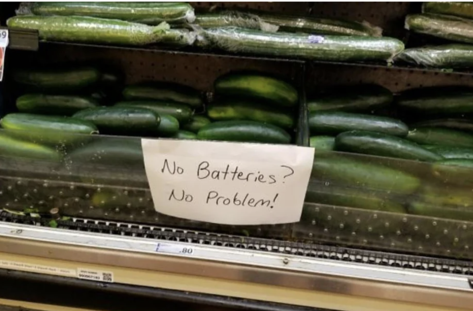 Display of cucumbers with handwritten sign: "No batteries? No problem!"