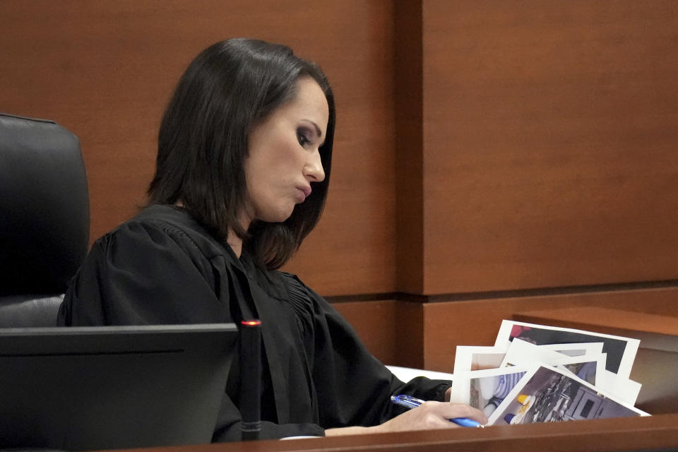 Judge Elizabeth Scherer flips through photographs submitted as exhibits during the penalty phase of the trial of Marjory Stoneman Douglas High School shooter Nikolas Cruz at the Broward County Courthouse in Fort Lauderdale, Fla., Monday, Aug. 29, 2022. Cruz previously plead guilty to all 17 counts of premeditated murder and 17 counts of attempted murder in the 2018 shootings. (Amy Beth Bennett/South Florida Sun Sentinel via AP, Pool)