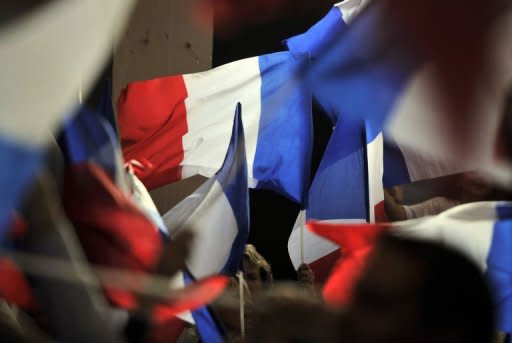 Supporters wave French flags during a campaign meeting of incumbent President Nicolas Sarkozy in the southwestern city of Avignon