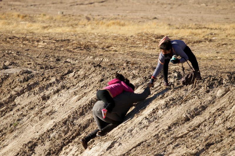 FILE PHOTO: Migrants walk out of the Rio Bravo river after crossing it to turn themselves in to U.S Border Patrol agents and request for asylum in El Paso, Texas, U.S., as seen from Ciudad Juarez