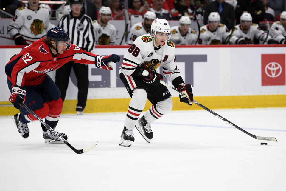 Chicago Blackhawks right wing Patrick Kane (88) skates with the puck against Washington Capitals left wing Carl Hagelin (62) during the second period of an NHL hockey game Thursday, Dec. 2, 2021, in Washington. (AP Photo/Nick Wass)