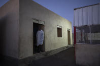 Tigrayan refugee Abraha Kinfe Gebremariam, 40, stands in a doorway of his family's shelter early morning in Hamdayet, eastern Sudan, near the border with Ethiopia, on March 21, 2021. His village of Mai Kadra was the first known massacre of a conflict in which thousands of ethnic Tigrayans like his family have been killed. (AP Photo/Nariman El-Mofty)