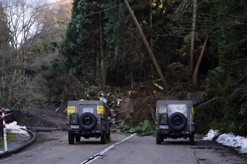 Members of the Japan Self-Defense Forces stay in their vehicles in front of a landslide that has shut down a road in Wajima in the Noto peninsula, facing the Sea of Japan, northwest of Tokyo, Friday, Jan. 5, 2024, following Monday's deadly earthquake. (AP Photo/Hiro Komae)