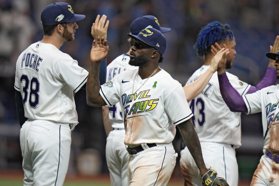Tampa Bay Rays left fielder Randy Arozarena, center, celebrates with teammates, including relief pitcher Colin Poche, left, after the Rays defeated the New York Yankees during a baseball game Friday, May 5, 2023, in St. Petersburg, Fla. (AP Photo/Chris O'Meara)