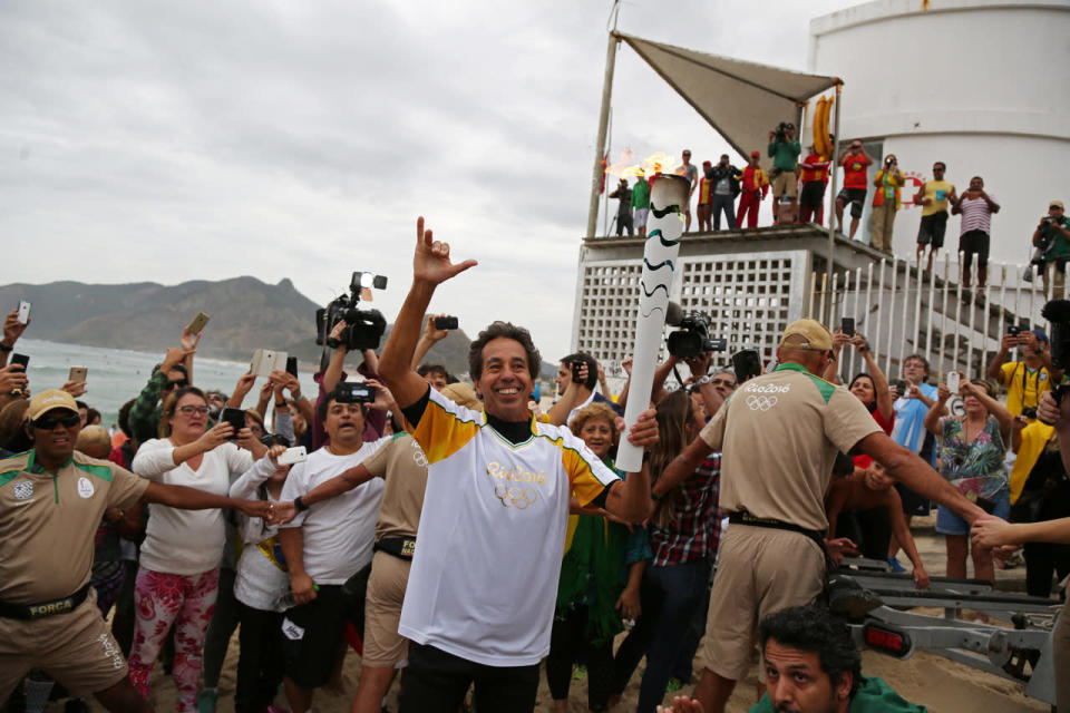 <p>Brazil’s Olympic torch relay</p><p>Brazilian surfer Rico de Souza holds up the Olympic torch after surfing with it at Praia da Macumba (Macumba beach) in Rio de Janeiro, Brazil August 4, 2016. (REUTERS/Pilar Olivares)</p>