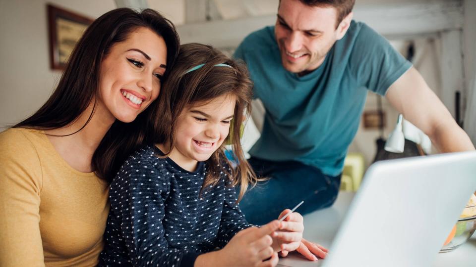 Family with a child using laptop and credit card.