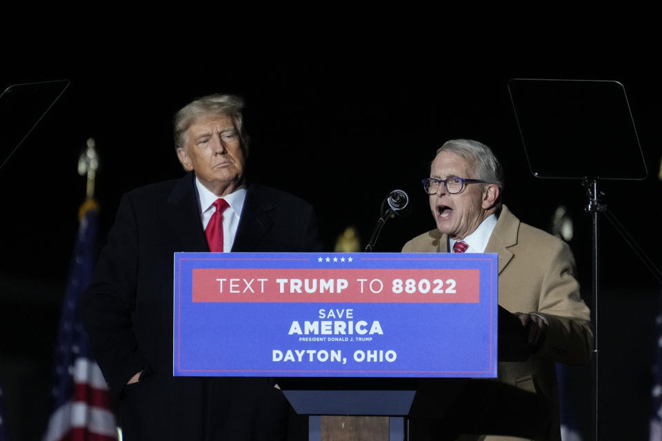 VANDALIA, OHIO - NOVEMBER 07:  Former U.S. President Donald Trump (L) looks on as Ohio Gov. Mike DeWine speaks at a rally for Ohio Republicans at the Dayton International Airport on November 7, 2022 in Vandalia, Ohio. Trump is campaigning for Republican candidates, including U.S. Senate candidate JD Vance, who faces U.S. Rep. Tim Ryan (D-OH) in tomorrow's general election.  (Photo by Drew Angerer/Getty Images)