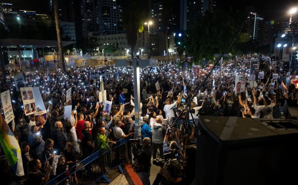 TEL AVIV, ISRAEL - NOVEMBER 25:Thousands of people and the families of hostages hold up their mobile phones with the torch light on to sing the national anthem during the â€˜50 Days of Hellâ€™ rally in support of the 212 hostages that are still being held by Hamas, as another 13 Israeli hostages are supposed to be released from Gaza and brought back to Israel, during the second day of the temporary truce, outside The Museum of Modern Art known as the 'The Hostages and Missing Square' on November 25, 2023 in Tel Aviv, Israel. According to event organizers 50,000 people were expected to attend with organized buses from around the country, as well as flights with the displaced families staying in Eilat of hostages from the communities around the Gaza Envelope. 100,000 people turned up according to event organizers. A total of 50 hostages currently held by Hamas are to be released during a four-day truce with Israel, the first such pause in fighting since Oct. 7, when Hamas launched its surprise attack and Israeli responded with a vast military offensive to destroy the militant group that governs Gaza. Under the deal, 150 Palestinian prisoners are also to be released from Israel, and more humanitarian aid will be admitted at the Gaza-Egypt border crossing. (Photo by Alexi J. Rosenfeld/Getty Images)