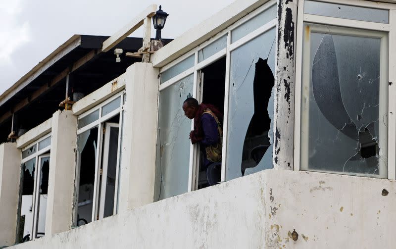 FILE PHOTO: A Somali police officer looks from the broken windows following an attack by Al Shabaab militants at the Liido beach in Mogadishu