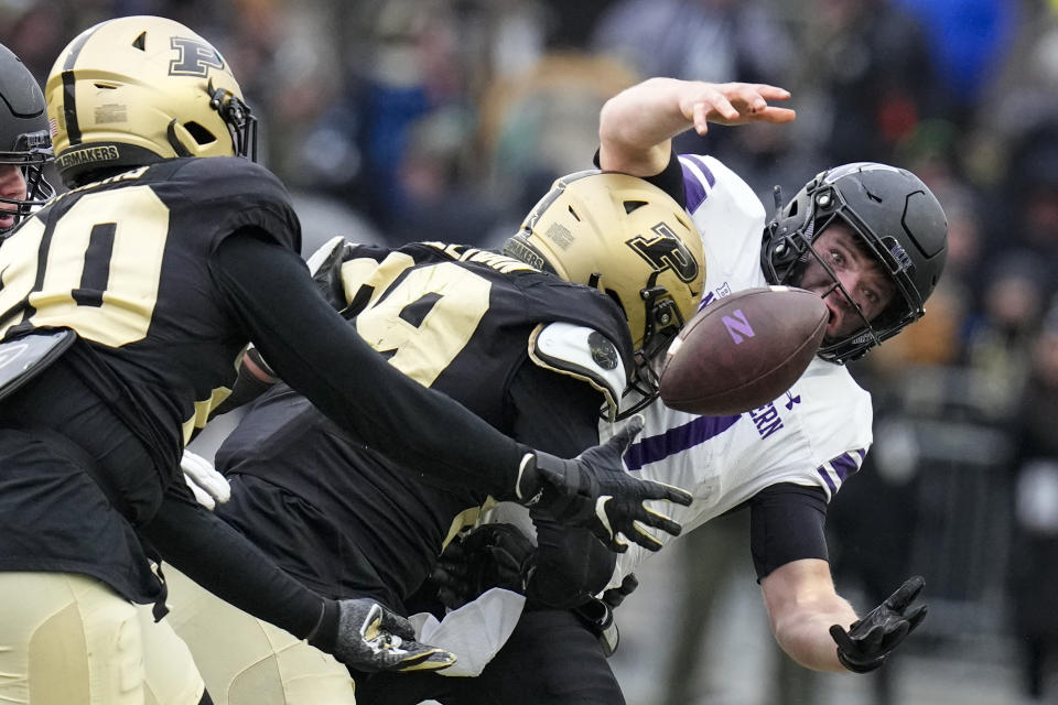 Northwestern quarterback Cole Freeman (7) fumbles as he's sacked by Purdue defensive end Jack Sullivan (99) at the end of the fourth quarter in an NCAA college football game in West Lafayette, Ind., Saturday, Nov. 19, 2022. Purdue linebacker OC Brothers, left, recovered the ball. Purdue defeated Northwestern 17-9. (AP Photo/Michael Conroy)