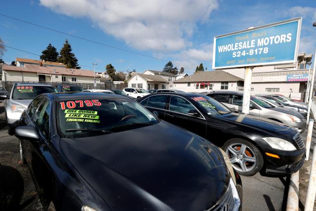 Used cars sit in the sales lot of a used car dealership in California.