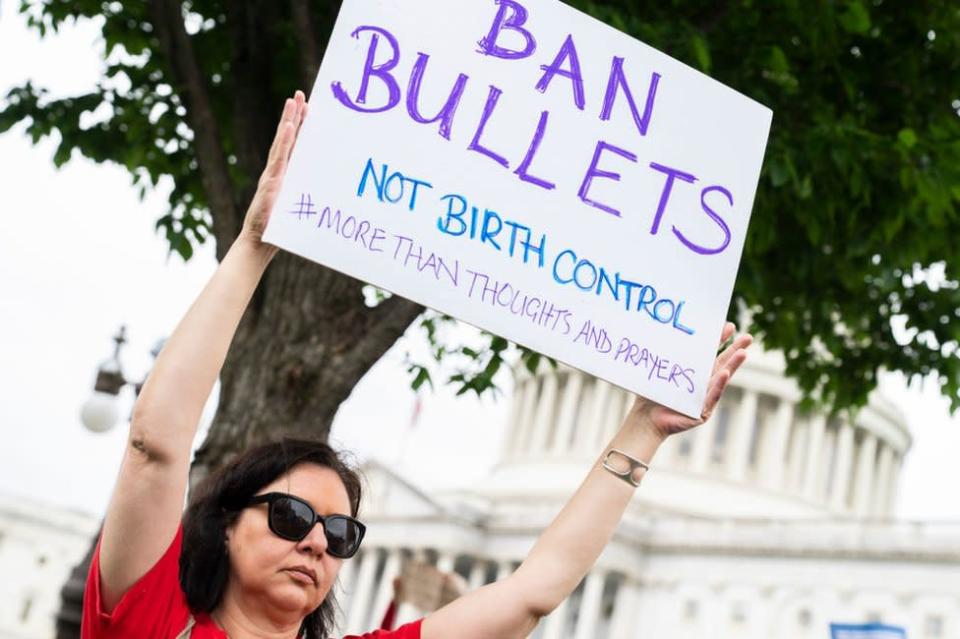 &quot;Prohíban las balas, no los anticonceptivos&quot;, se lee en el cartel que sostiene una manifestante frente al Capitolio el 26 de mayo de 2022.