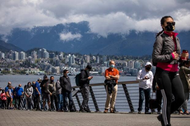 Essential workers line up outside the Vancouver Convention Centre during a COVID-19 vaccination clinic on May 7.  (Ben Nelms/CBC - image credit)