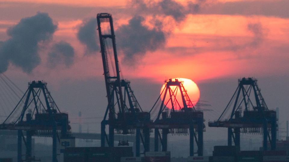 Sonnenuntergang hinter den Containerbrücken des HHLA Containerterminal Tollerort in Hamburg. Die Corona-Krise reißt tiefe Löcher in den Staatshaushalt.