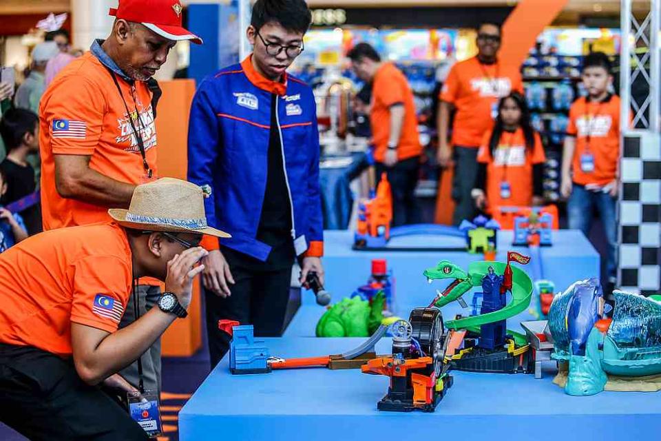 One of the parents from the child-parent teams looks on nervously as their Hot Wheels car attempts to go through the snake’s head. — Picture courtesy of Hot Wheels Malaysia