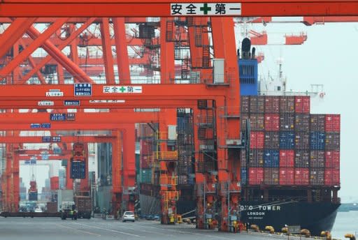 Containers are unloaded from a cargo ship at a pier in Tokyo on March 8, 2012. Japan logged its biggest ever current account deficit in January as exports stuttered and rising fuel costs continued to bite