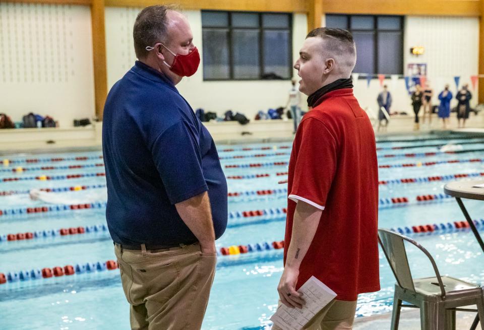 Brad and Chase Smith talk about a race after their boys placed first in a medley relay at Indian Creek High School in Trafalgar, Ind., on Tuesday, Dec. 8, 2020. 