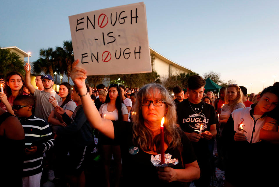 <p>Mourners stand during a candlelight vigil for the victims of Marjory Stoneman Douglas High School shooting in Parkland, Fla., on Feb. 15, 2018. (Photo: Rhona Wise/AFP/Getty Images) </p>