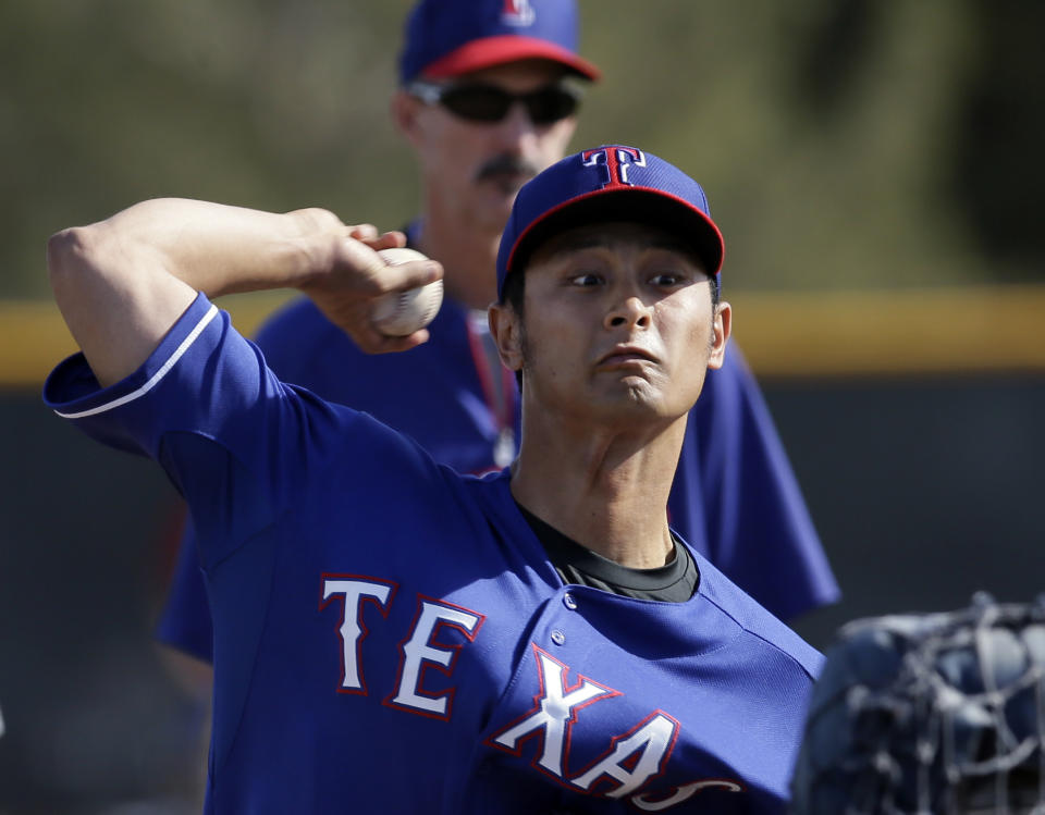 Texas Rangers' Yu Darvish, of Japan, throws batting practice as pitching coach Mike Maddux watches during baseball spring training Tuesday, Feb. 18, 2014, in Surprise, Ariz. (AP Photo/Tony Gutierrez)