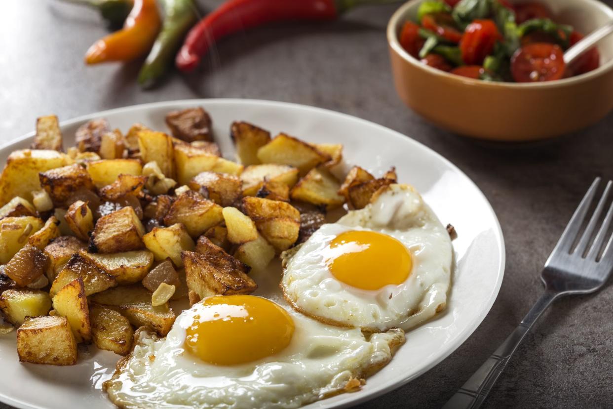 Eggs and Fries with small pieces of fat pork meat, onion and garlic on plate