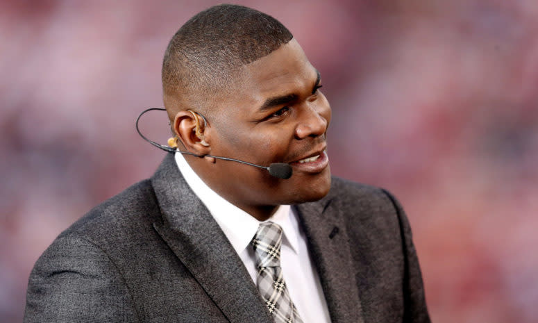 Keyshawn Johnson smiles while wearing a headset.