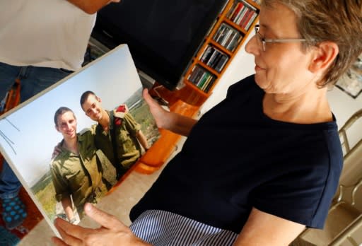Lean Goldin holds a picture of her son Hadar (L) in the family home in Kfar Saba, central Israel