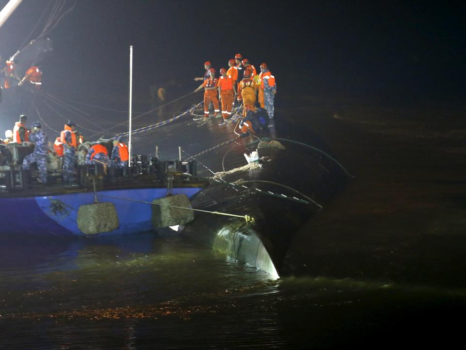 Rescue workers are seen atop a sunken ship in the Jianli section of Yangtze River, Hubei province