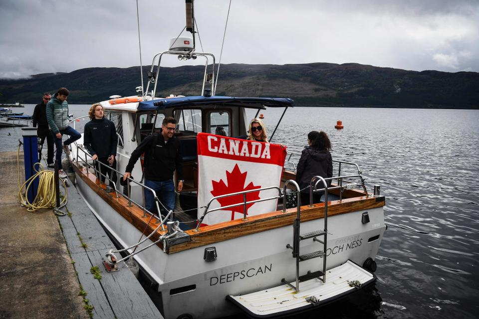 A Canadian flag is held as Loch Ness Research Project vessel 'Deepscan' takes monster hunters on a search trip on Loch Ness in the hope of spotting the elusive monster Nessie in Scotland on Aug. 27, 2023. The biggest search for the Loch Ness Monster in five decades got underway in the Scottish Highlands, as researchers and enthusiasts from around the world braved pelting rain to try to track down the elusive Nessie.