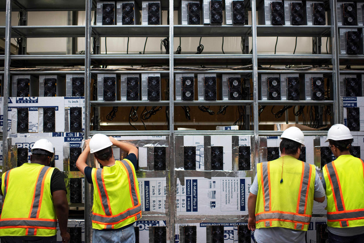 Workers install a new row of Bitcoin mining machines (Mark Felix / AFP via Getty Images file)
