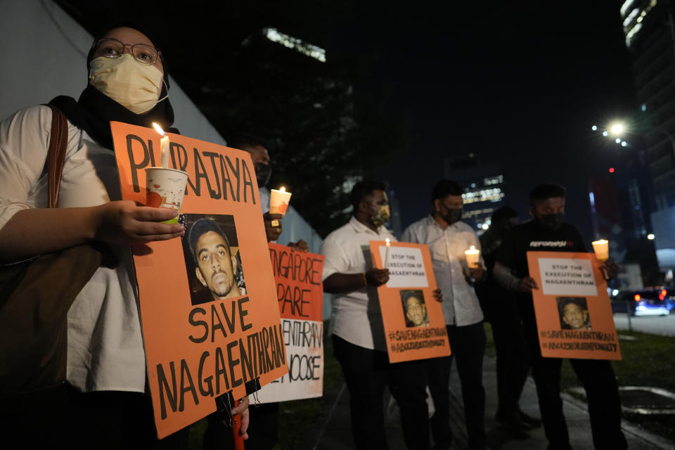 Activists holds posters against the impending execution of Nagaenthran K. Dharmalingam, sentenced to death for trafficking heroin into Singapore, during a candlelight vigil gathering outside the Singaporean Embassy in Kuala Lumpur, Malaysia, Tuesday, April 26, 2022. The Singapore Court of Appeal has dismissed a last-minute legal challenge filed by the mother of a mentally disabled Malaysian man in an attempt to halt his execution for drug trafficking. (AP Photo/Vincent Thian)