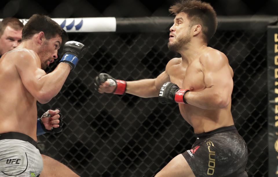 Henry Cejudo, right, punches Dominick Cruz during a UFC 249 mixed martial arts bout, Saturday, May 9, 2020, in Jacksonville, Fla. (AP Photo/John Raoux)