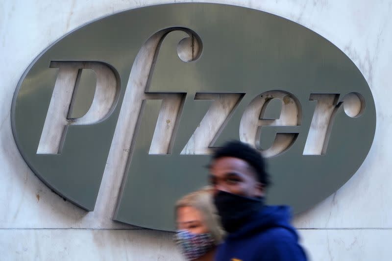 People walk past the Pfizer Headquarters building