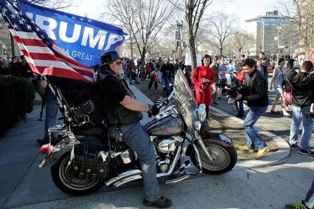 A Trump supporter watches protesters marching towards the White House during the "Not My President's Day" rally in Washington, U.S., February 20, 2017. REUTERS/Yuri Gripas