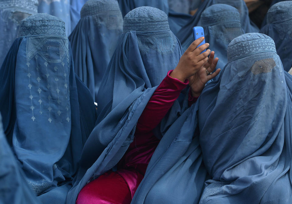A woman takes a photograph with her mobile phone as she and supporters attend the election rally of presidential candidate Abdullah Abdullah in Jalalabad on Feb. 18, 2014.