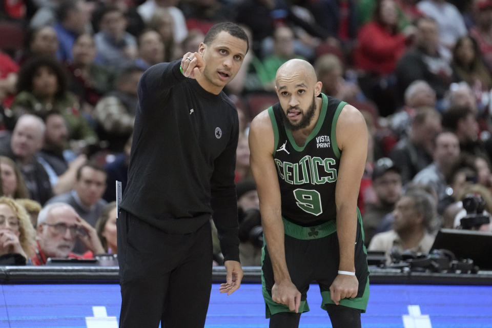 Boston Celtics head coach Joe Mazzulla, left, talks with Derrick White, right, during the first half of an NBA basketball game against the Chicago Bulls, Thursday, Feb. 22, 2024, in Chicago. (AP Photo/Charles Rex Arbogast)