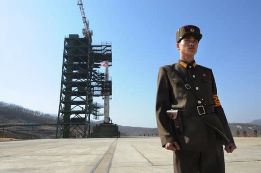 A North Korean soldier stands guard in front of the Unha-3 rocket at Tangachai -ri space center on April 8, 2012. The UN Security Council on Wednesday put three top North Korean state firms on a sanctions black list over the country's failed rocket launch