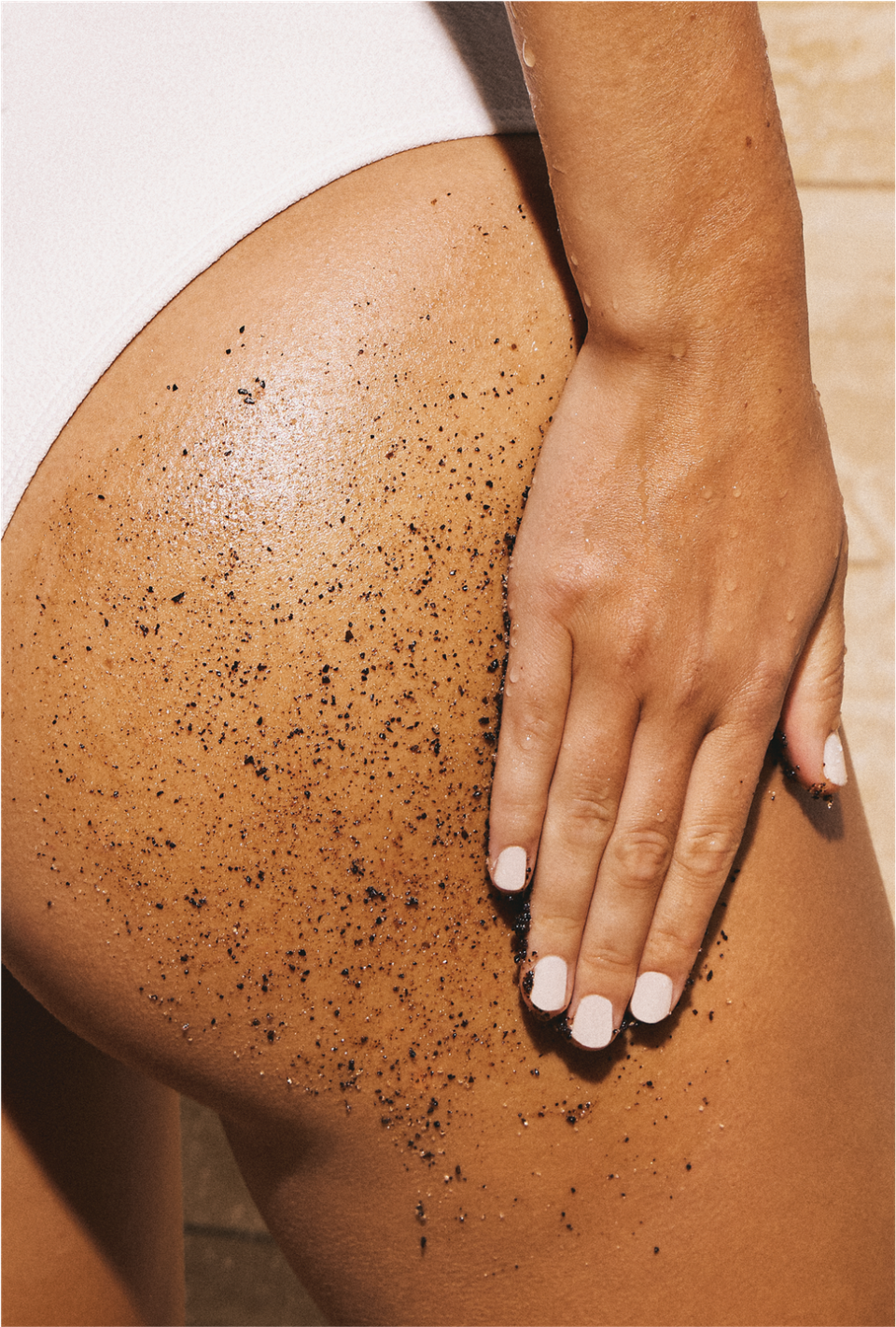 woman scrubbing butt with exfoliant