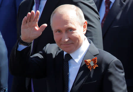 Russian President Vladimir Putin waves towards the crowd as he leaves after attending the Victory Day parade, marking the 73rd anniversary of the victory over Nazi Germany in World War Two, at Red Square in Moscow, Russia May 9, 2018. REUTERS/Maxim Shemetov/Files