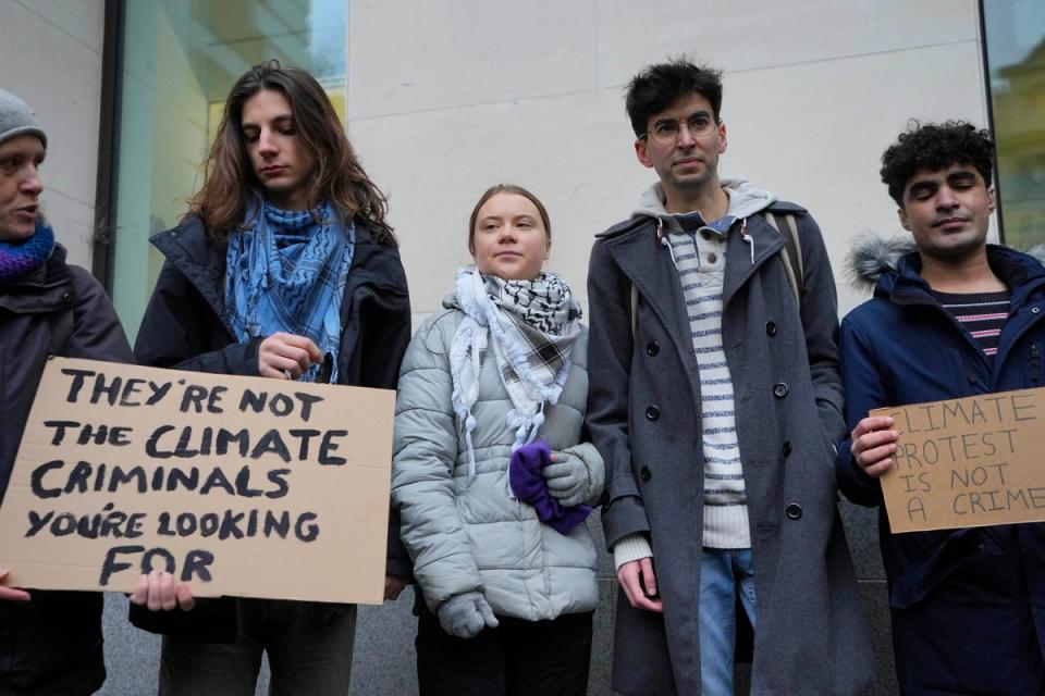 Greta Thunberg, centre,  with other protesters at Westminster Magistrates Court on Friday (AP)