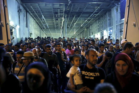 Refugees and migrants disembark from the passenger ship "Tera Jet", following their trip from the island of Lesbos to the port of Piraeus, near Athens, Greece September 1, 2015. REUTERS/Alkis Konstantinidis